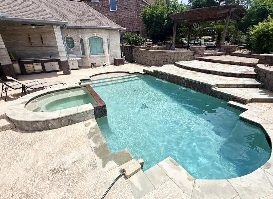 Large pool and spa with stone patio and pergola