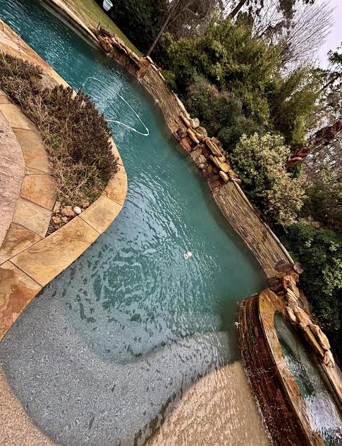 Pool with natural stone waterfall and beach entry